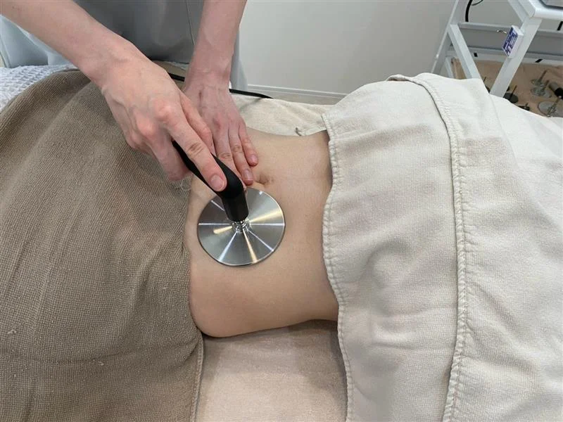 腹部に高周波機器を当てるインディバ施術の手元